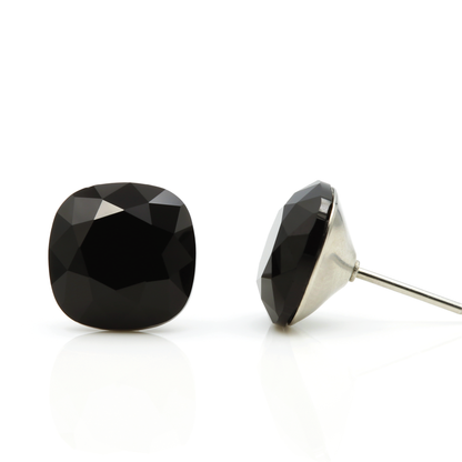 Seona Sophia Cushion Crystal Stud Earrings in Black, showcasing a stylish cushion cut design with a sparkling finish, laid out against a pure white background.